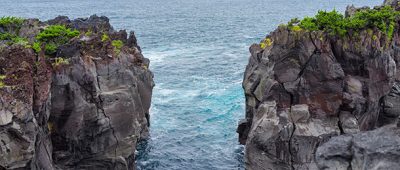 Ocean view with rock cliffs either side.