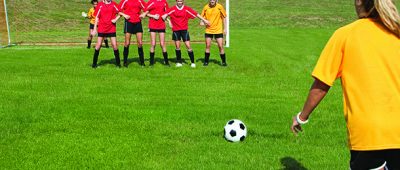 Female soccer player taking free kick